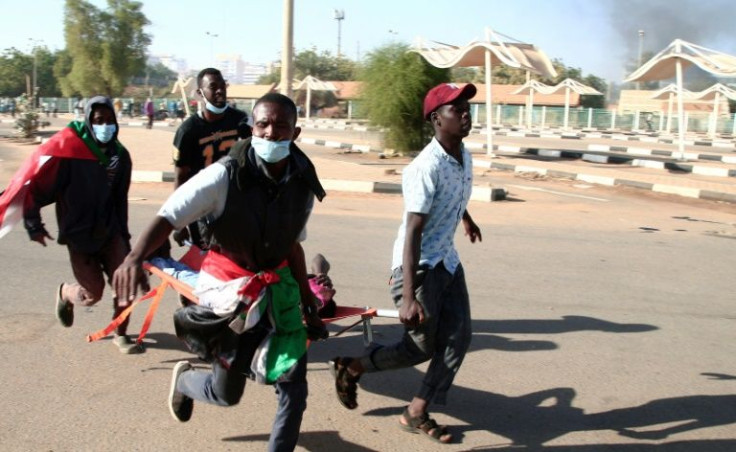 Sudanese protesters carry a wounded youth on a stretcher, during a demonstration in the capital Khartoum, on January 2, 2022