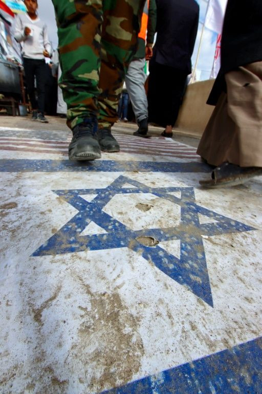 Mourners stepped on US and Israeli flags as they commemorated Soleeimani and slain Iraqi commander Abu Mahdi al-Muhandis in Najaf on January 3, 2022