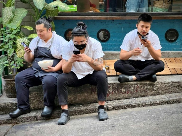 Masked restaurant workers take a break outside their workplace in Hong Kong