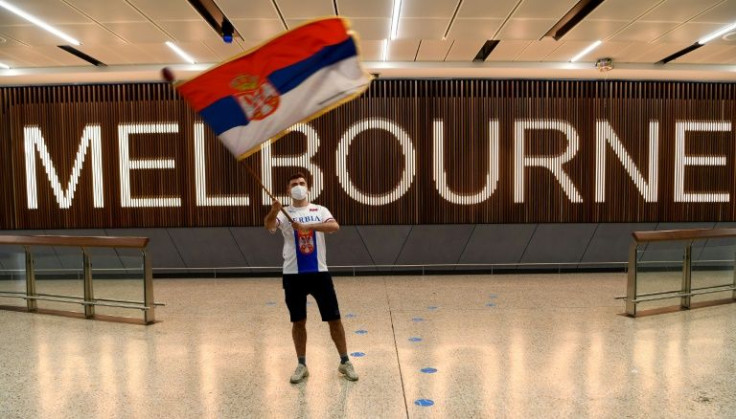 A Serbian tennis fan waves a flag as he awaits Novak Djokovic in Melbourne on January 6, 2022, shortly before Australian officials cancelled the tennis star's entry visa
