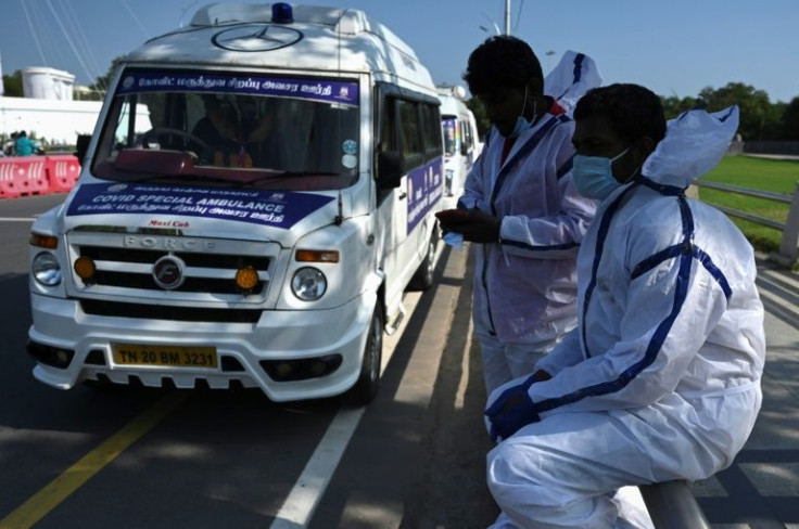 Ambulance support staff prepare for their shift next to special Covid ambulances in Chennai