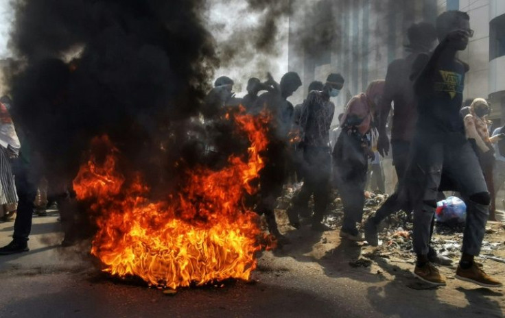 Sudanese protesters rallying against the military walk past burning tyres in the capital Khartoum on January 6, 2021