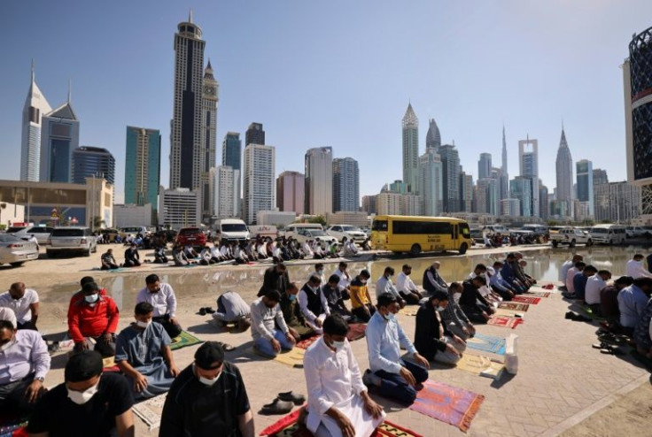 Muslim men perform Friday noon prayer in an area close to their workplace on the first working Friday in the Gulf emirate of Dubai