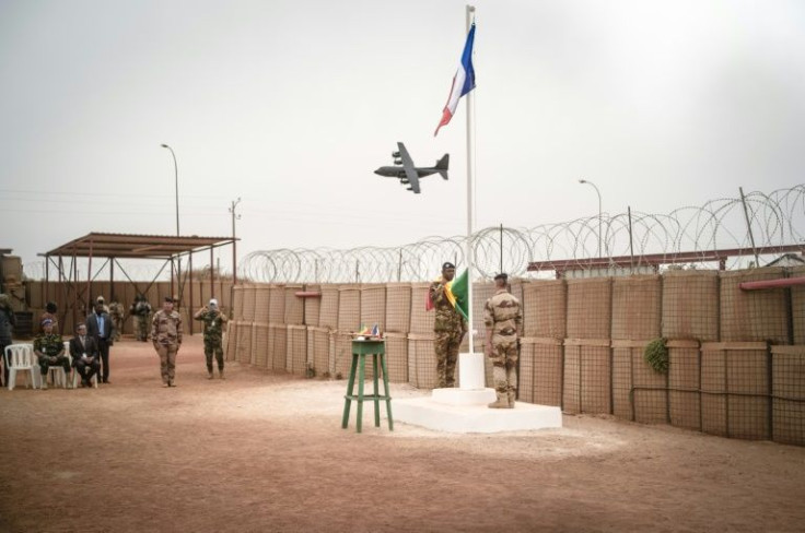 French forces prepare to lower the tricolore flag at the Timbuktu base on December 14, handing the facility to the Malian army