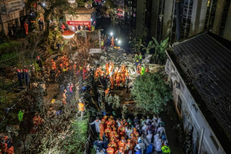 Rescuers search at the scene of an explosion that caused a building to collapse in Chongqing, killing at least 16 people