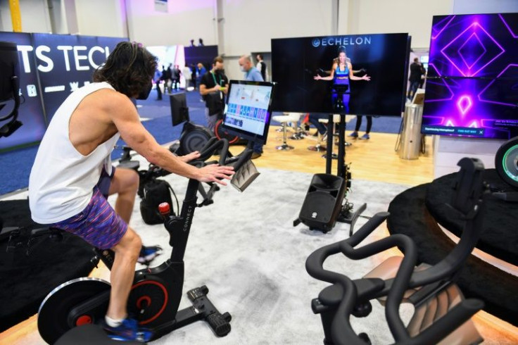 An attendee rides an Echelon exercise bike while an instructor is displayed on screen during the Consumer Electronics Show (CES) on January 7, 2022 in Las Vegas, Nevada
