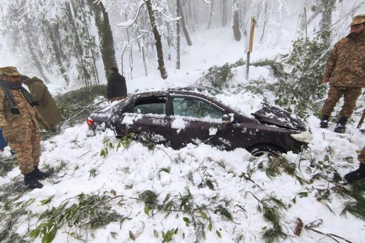 Soldiers clear snow from a trapped car near Murree in this handout photograph released by Pakistan's Inter Services Public Relations