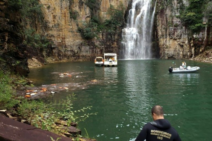 Rescuers are seen on January 8, 2022 after a cliff collapsed onto boats on a lake in Brazil, killing multiple people
