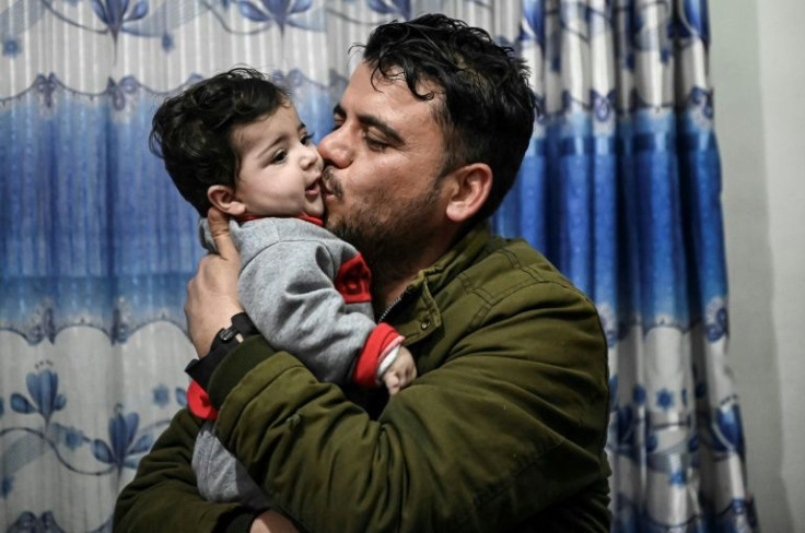 Sohail Ahmadi is given a kiss by Hamid Safi, a taxi driver who found the boy after he was lost at Kabul airport