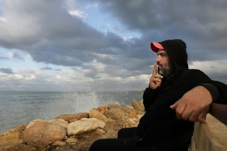 Bilal Moussa, 34, smokes near the waters off Tripoli that almost swallowed him -- but he vows to try again to flee Lebanon's poverty
