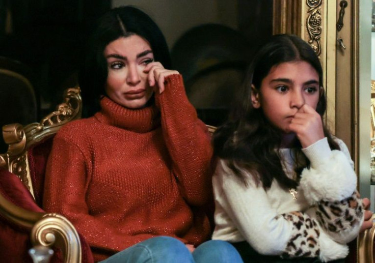 Sarah, 32, a Lebanese would-be migrant, wipes tears as she listens to her husband talk about their failed effort to reach Europe