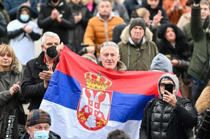 A demonstrator waves Serbian national flag as he takes part in a rally in front of Serbia's National Assembly against Australia's decision to revok Djokovic's visa