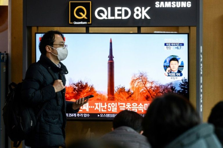 A man walks past a news broadcast showing footage of a North Korean missile test, at a railway station in Seoul on January 11, 2022