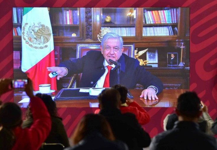 Mexican President Andres Manuel Lopez Obrador checks his blood oxygen level during an appearance by video link on January 11, 2022, a day after announcing he had caught Covid-19 for a second time