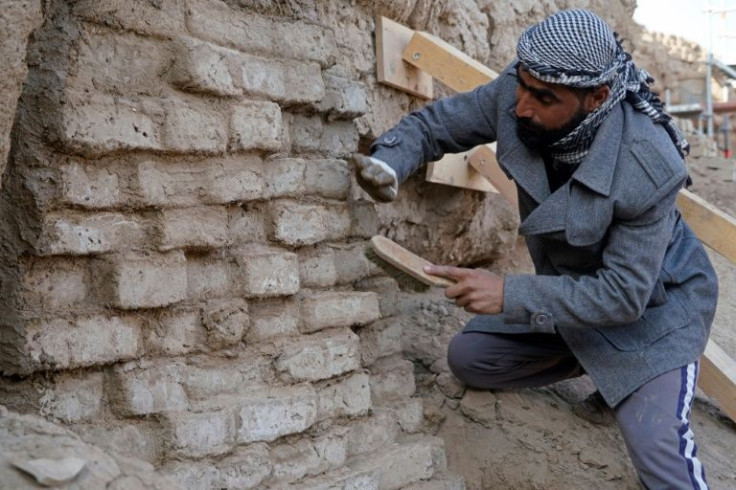 Iraqi archaeologists and workers use traditionally-made clay bricks to restore the white temple of Anu in the Warka site in Iraq's Muthanna province, on November 27, 2021