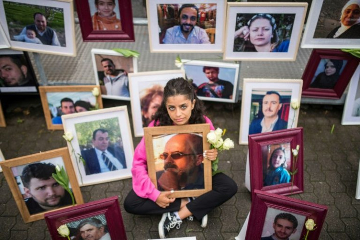 Syrian activist Wafa Mustafa holds a picture of her father, one of many victims of abuses under Syria's regime