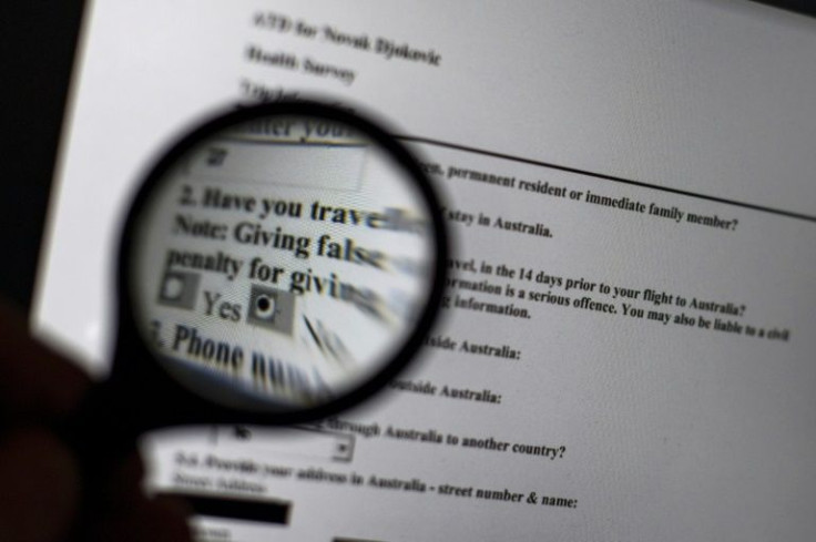 A magnifying glass highlights a released copy of Serbian tennis champion Novak Djokovic's health survey submitted during his Australian visa application process for his arrival in Melbourne ahead of the Australian Open tennis tournament