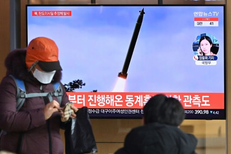 People at a Seoul train station watch a television news broadcast showing file footage of a North Korean missile test on January 5, 2021