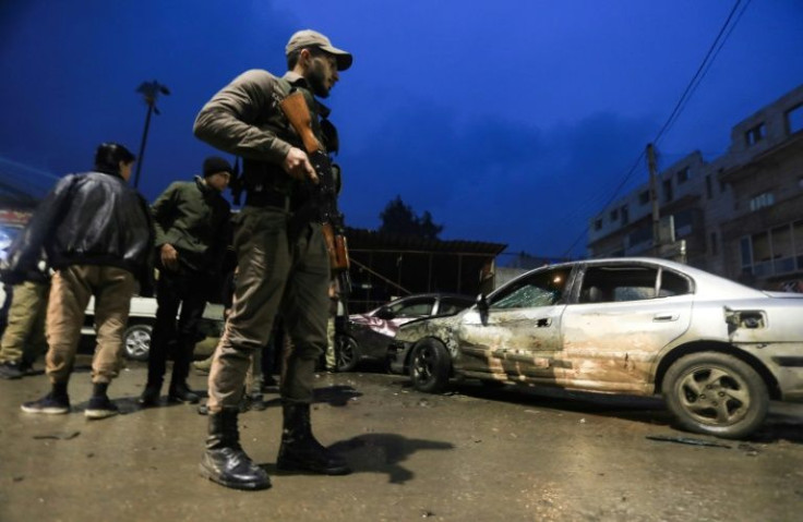 A Syrian fighter stands at the scene of an explosion that took place in the Syrian city of Al-Bab on January 13