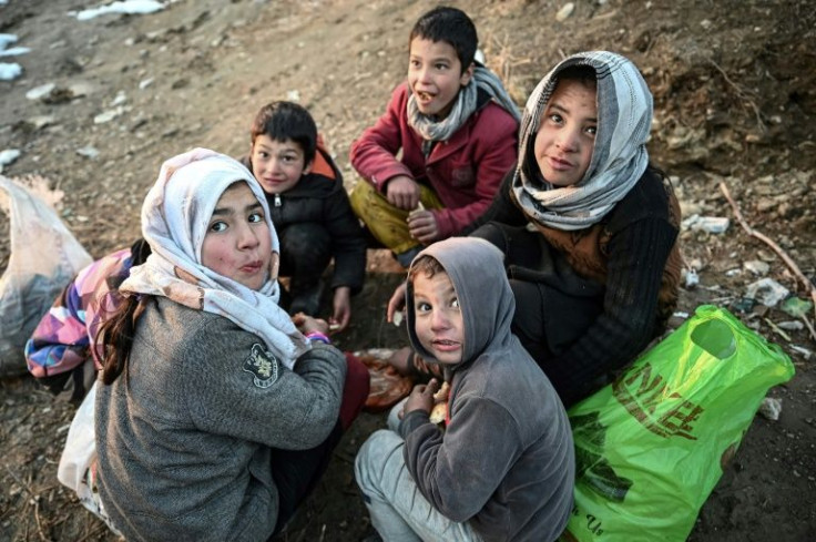 Children eat bread at the Wazir Akbar Khan hill on January 11, 2022