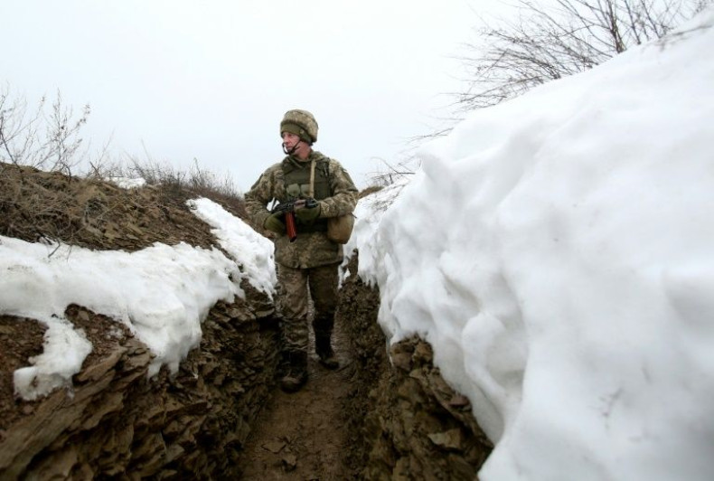 An Ukrainian soldier walks in a trench on the frontline with Russia-backed separatists near Luganske village in the Donetsk region on January 11, 2022