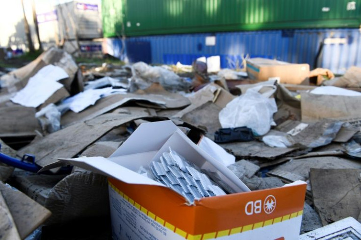 An open box of unused Covid-19 tests is left behind on a section of Union Pacific train tracks littered with thousands of opened boxes and packages stolen from cargo shipping containers, targeted by thieves as the trains stop in downtown Los Angeles