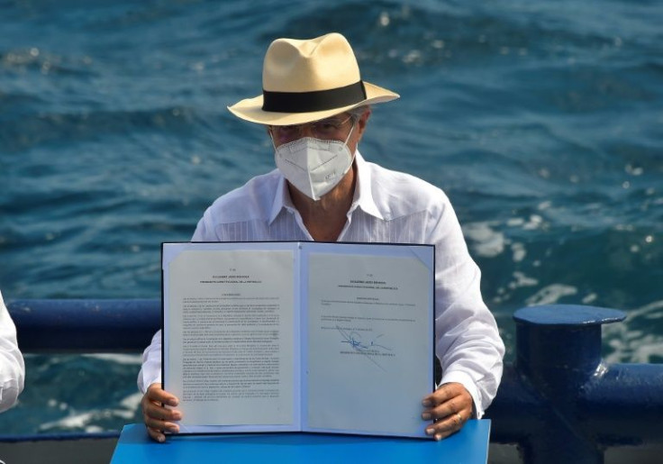 Ecuador's President Guillermo Lasso shows the decree for the expansion of the Galapagos marine reserve