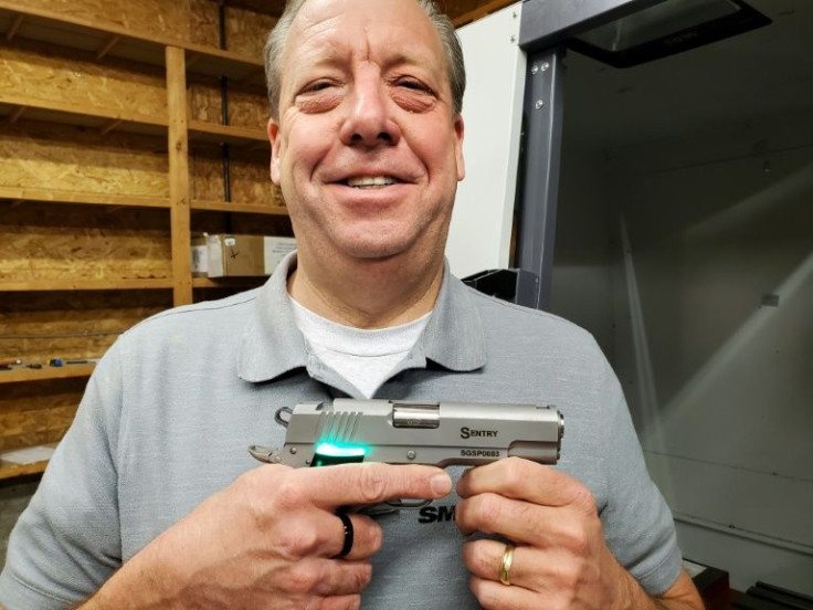 This undated handout photo courtesy of SmartGunz, LLC, shows company President G. Thomas (âTomâ) Holland II posing while he holds his product in Baldwin City, Kansas