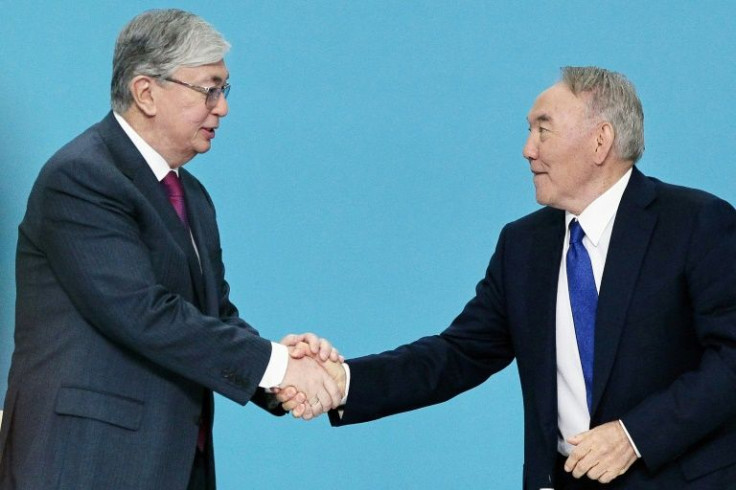 Former Kazakh president Nursultan Nazarbayev shakes hands with his hand-picked successor President Kassym-Jomart Tokayev in this 2019 file picture