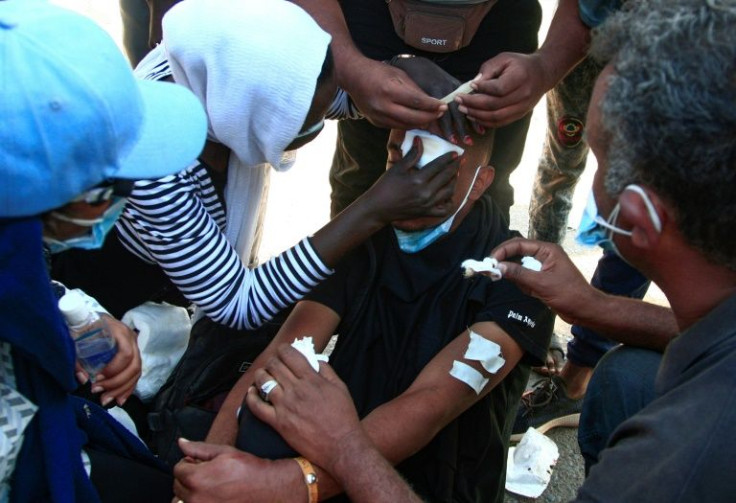 Sudanese protesters treat a young man's wounds at the scene of confrontations with security forces, in the capital Khartoum on December 25, 2021, during a demonstration demanding civilian rule