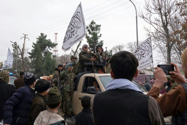 Heavily armed fighters in jungle camouflage rode on the back of pick-up trucks