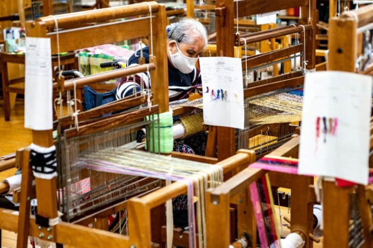 A worker makes crafts for a welfare trade shop that sells items made by hand by people with various disabilities