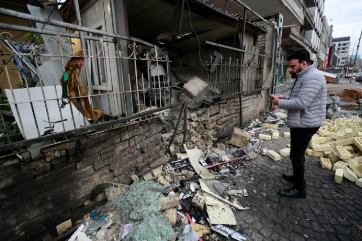 An man checks the scene of an explosion outside a Kurdish bank in Iraq's capital Baghdad on January 17