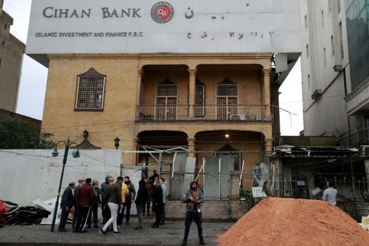 Iraqi onlookers look at the damage caused by a blast outside a Kurdish bank in Baghdad