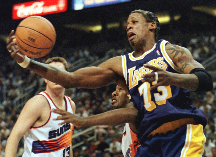Los Angeles Lakers forward Dennis Rodman pulls in a rebound in front of Phoenix Suns forward Clifford Robinson