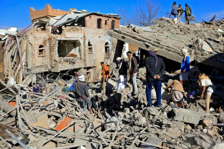 Yemenis survey the damage after the Saudi-led coalition carried out retaliatory air strikes against the rebel-held capital Sanaa following a rebel drone and missile attack on the United Arab Emirates