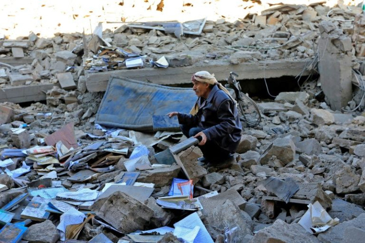 Yemenis inspect the damage following overnight air strikes by the Saudi-led coalition targeting the Huthi rebel-held capital Sanaa, on January 18, 2022