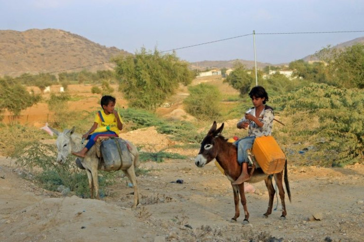 Yemeni children ride donkeys to fill their jerrycans with water at a make-shift camp for the internally displaced, in the northern Hajjah province, on January 16, 2022, amid a severe shortage of water
