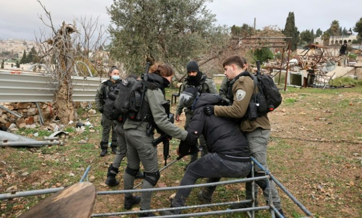 Israeli police lead away a Palestinian on crutches during the eviction and demolition operation in east Jerusalem's sensitive Sheikh Jarrah neighbourhood