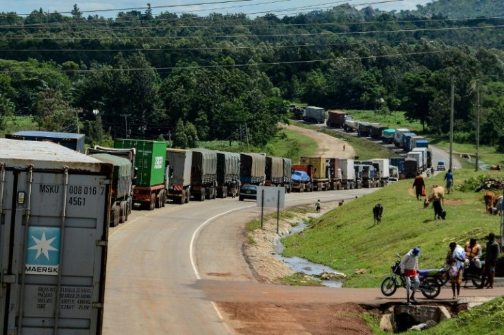 Trucks wait to enter Uganda where one city has prohibited drivers from permitting 'even their wives' in the front cabin of lorries