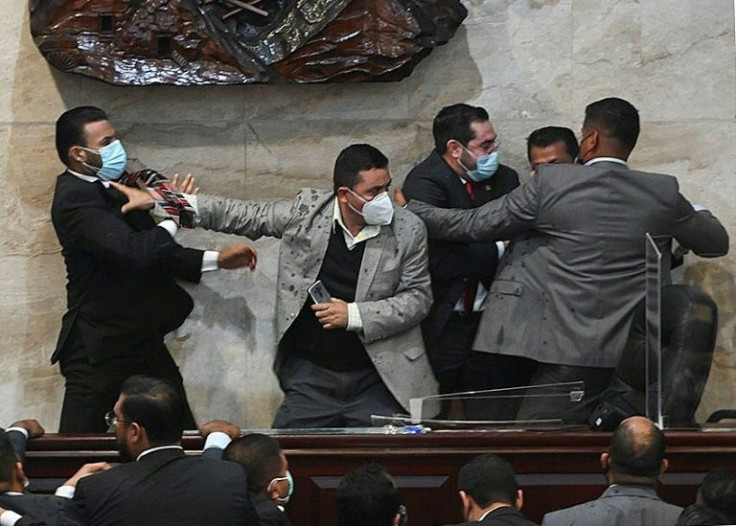Libre Party lawmaker Rassel Tome (L) tries to attack deputy Jorge Calix (2-R) in Tegucigalpa on January 21, 2022