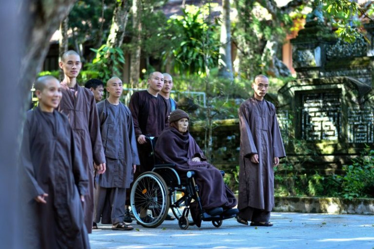 This photo taken on November 15, 2018 shows then-92-year-old Vietnamese Buddhist monk Thich Nhat Hanh (C) in a wheelchair at the Tu Hieu pagoda in Hue
