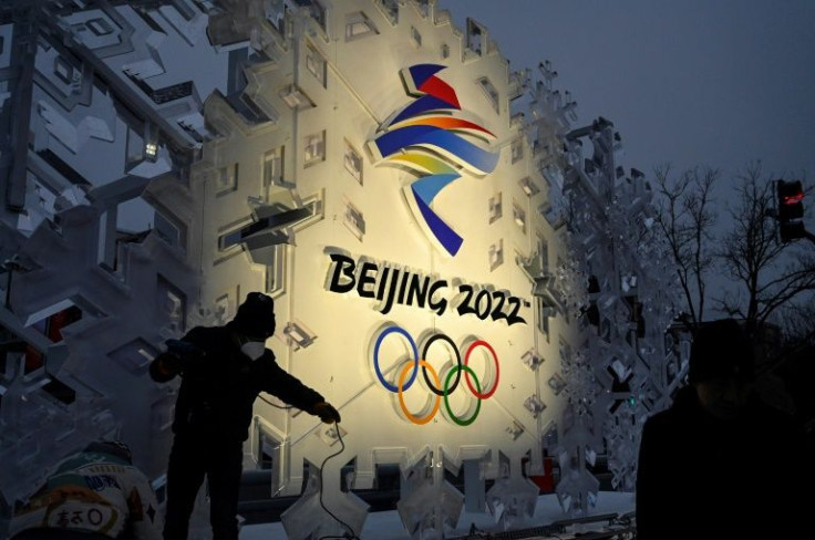 Workers set up an installation displaying the logo of the Beijing Winter Olympics