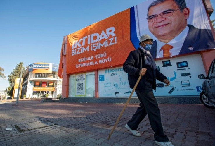 A man passes an election poster in the northern part of divided Nicosia -- analysts said there has been a lack of interest in the poll among the roughly 204,000 voters