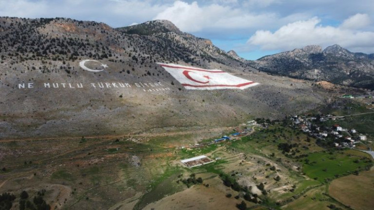 The flag of the self-proclaimed Turkish Republic of Northern Cyprus (TRNC) is next to a quote by Turkish Republic founder Mustafa Kemal Ataturk, reading in Turkish: "Happy are they who call themselves a Turk", north of the divided capital Nicosia