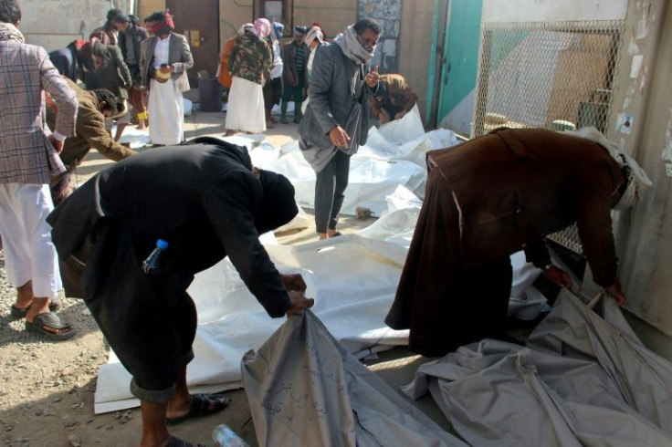 Yemenis inspect the bodies of victims a day after reported Saudi-led airstrikes in the Huthi stronghold of Saada on January 22, 2022