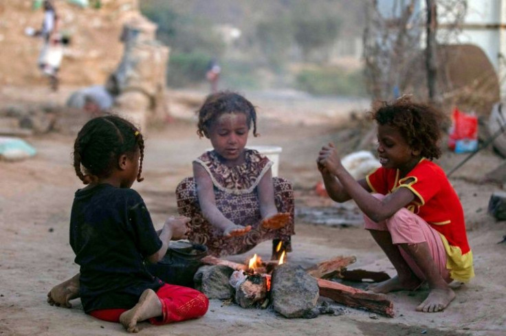 Yemeni children sit by a fire at a camp for displaced people outside the city of Taez, victims of a conflict that has left the country in ruins