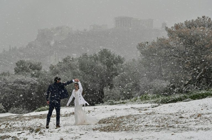 A newlywed couple from the United States enjoyed the snowfall during a photo shoot in Athens