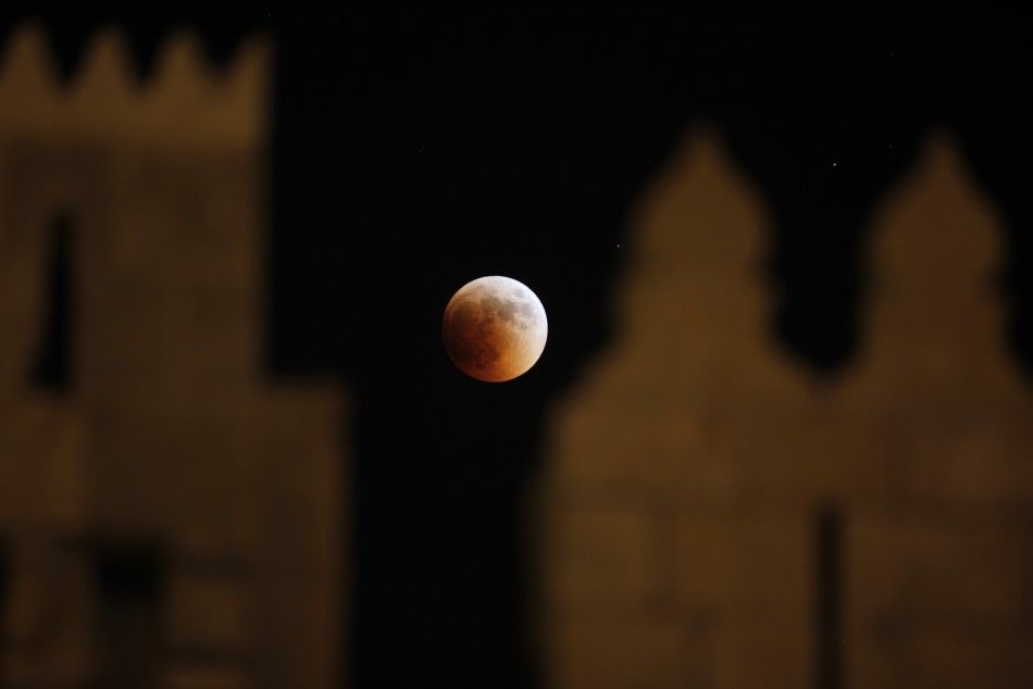 The moon is seen behind the wall of Damascus gate in Jerusalem Old City during a total lunar eclipse