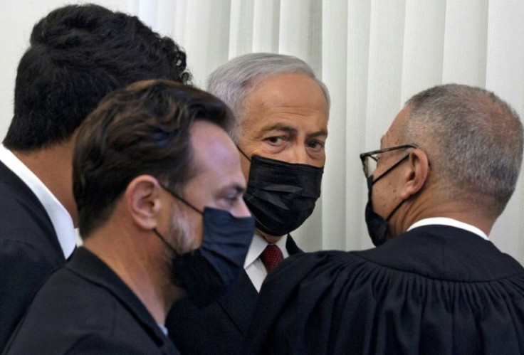 Former Israeli prime minister Benjamin Netanyahu (C) is flanked by lawyers before testimony by star witness Nir Hefetz, a former aide, during his corruption trial in east Jerusalem, on November 22, 2021